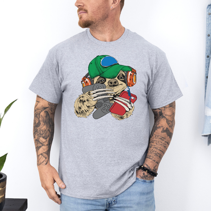 A man wearing a grey t-shirt with a cartoon sloth graphic wearing a cap, oversized headphones, while holding a grey gaming controller and red phone, set against a white wall background. Grab your tee from Coffee and Moo NZ.