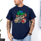 A man wearing a navy blue t-shirt with a cartoon sloth graphic wearing a cap, oversized headphones, while holding a grey gaming controller and red phone, set against a white wall background. Grab your tee from Coffee and Moo NZ.