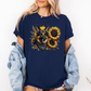 A man wearing a navy short-sleeve t-shirt with a graphic print of a German Shepherd dog surrounded by yellow sunflowers, paired with light blue jeans. Grab your tee from Coffee and Moo NZ.
