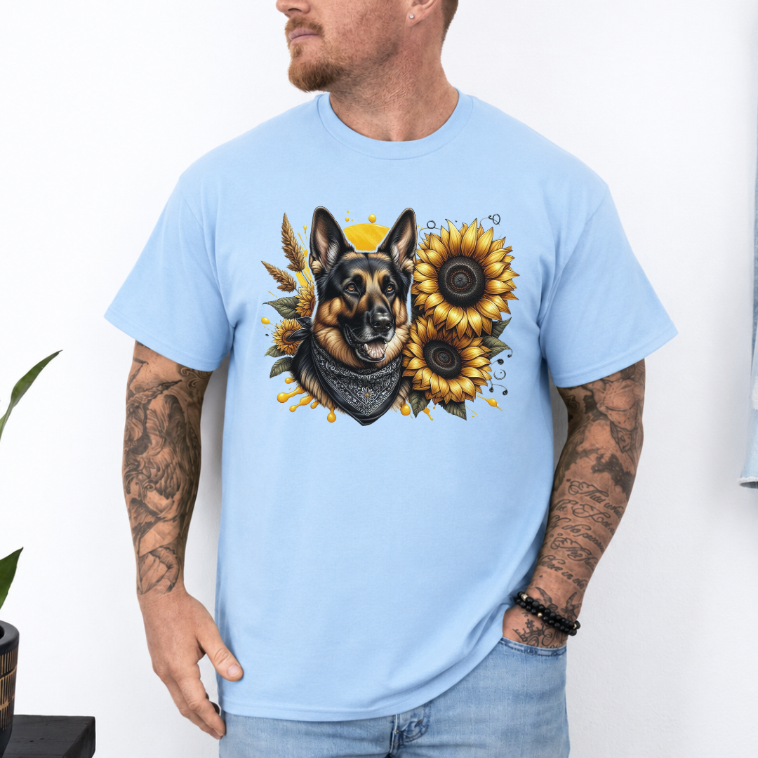 A man wearing a light blue short-sleeve t-shirt with a graphic print of a German Shepherd dog surrounded by yellow sunflowers, paired with light blue jeans. Grab your tee from Coffee and Moo NZ.