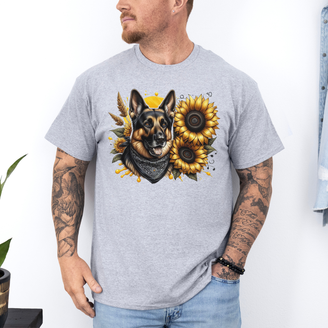 A man wearing a grey short-sleeve t-shirt with a graphic print of a German Shepherd dog surrounded by yellow sunflowers, paired with light blue jeans. Grab your tee from Coffee and Moo NZ.