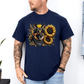 A man wearing a navy short-sleeve t-shirt with a graphic print of a German Shepherd dog surrounded by yellow sunflowers, paired with light blue jeans. Grab your tee from Coffee and Moo NZ.