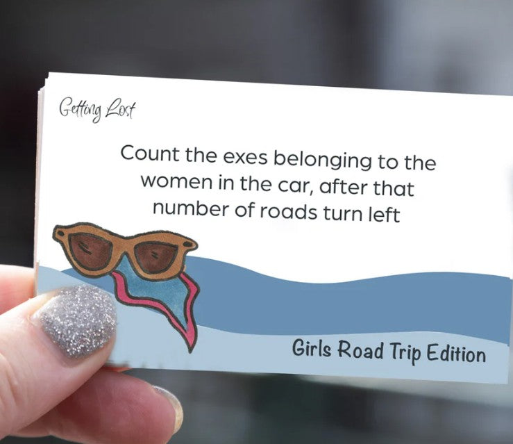 A card from the 'Getting Lost Girls Road Trip Edition' game. card reads "count the exes belonging to the women in the car, after that number of roads turn left". Pack Includes 26 direction and activity cards, ready for a weekend getaway. Purchase yours from Coffee and Moo NZ