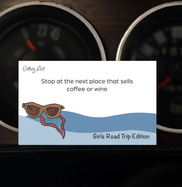A card from the 'Getting Lost Girls Road Trip Edition' game. card reads " Stop at the next place that sells coffee or wine". Pack Includes 26 direction and activity cards, ready for a weekend getaway. Purchase yours from Coffee and Moo NZ