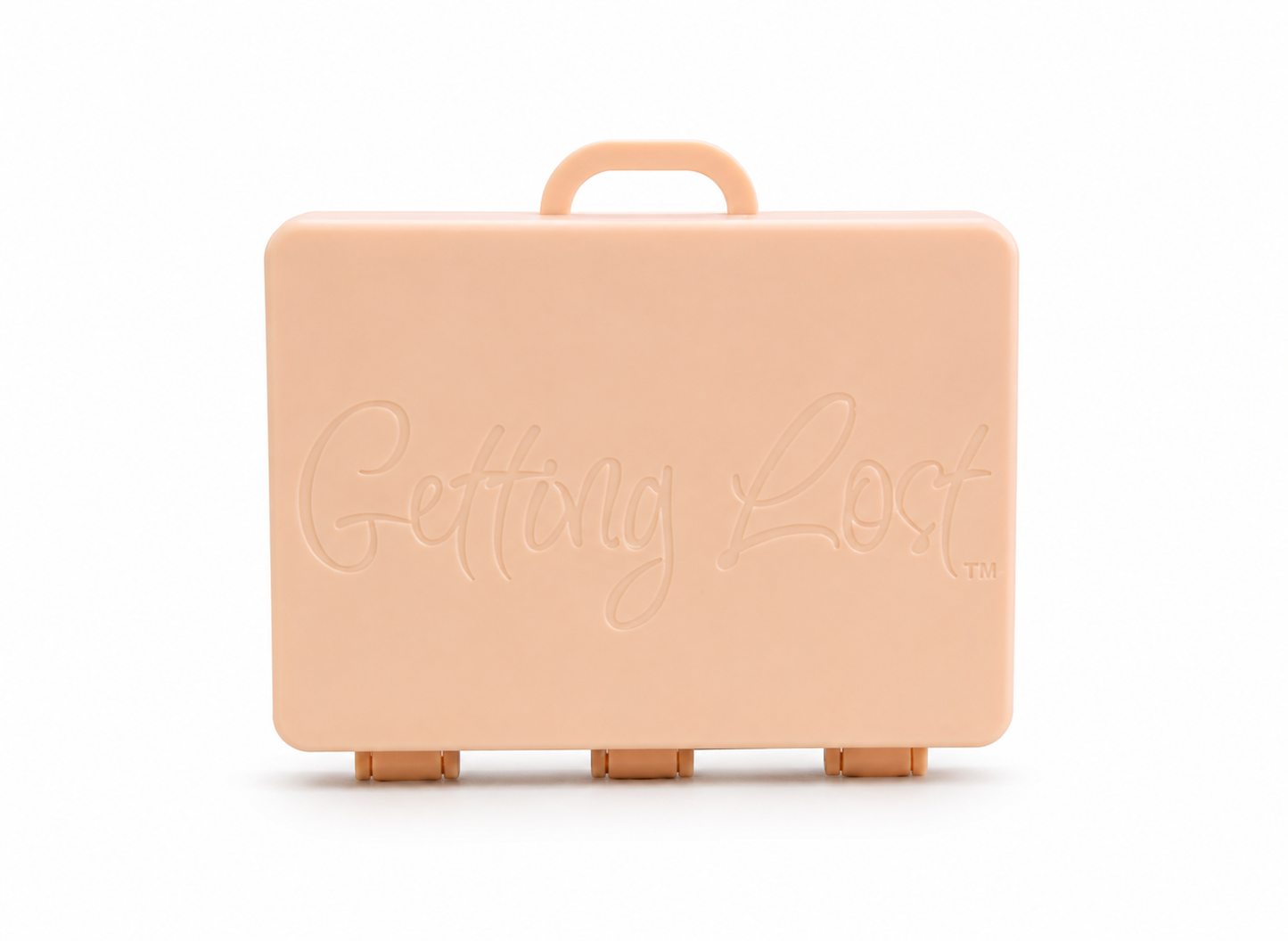 A pastel peach rectangular carrying case with a top handle, featuring the words 'Getting Lost' embossed on the front, set against a plain white background. For the Getting lost card game. Purchase from Coffee and Moo