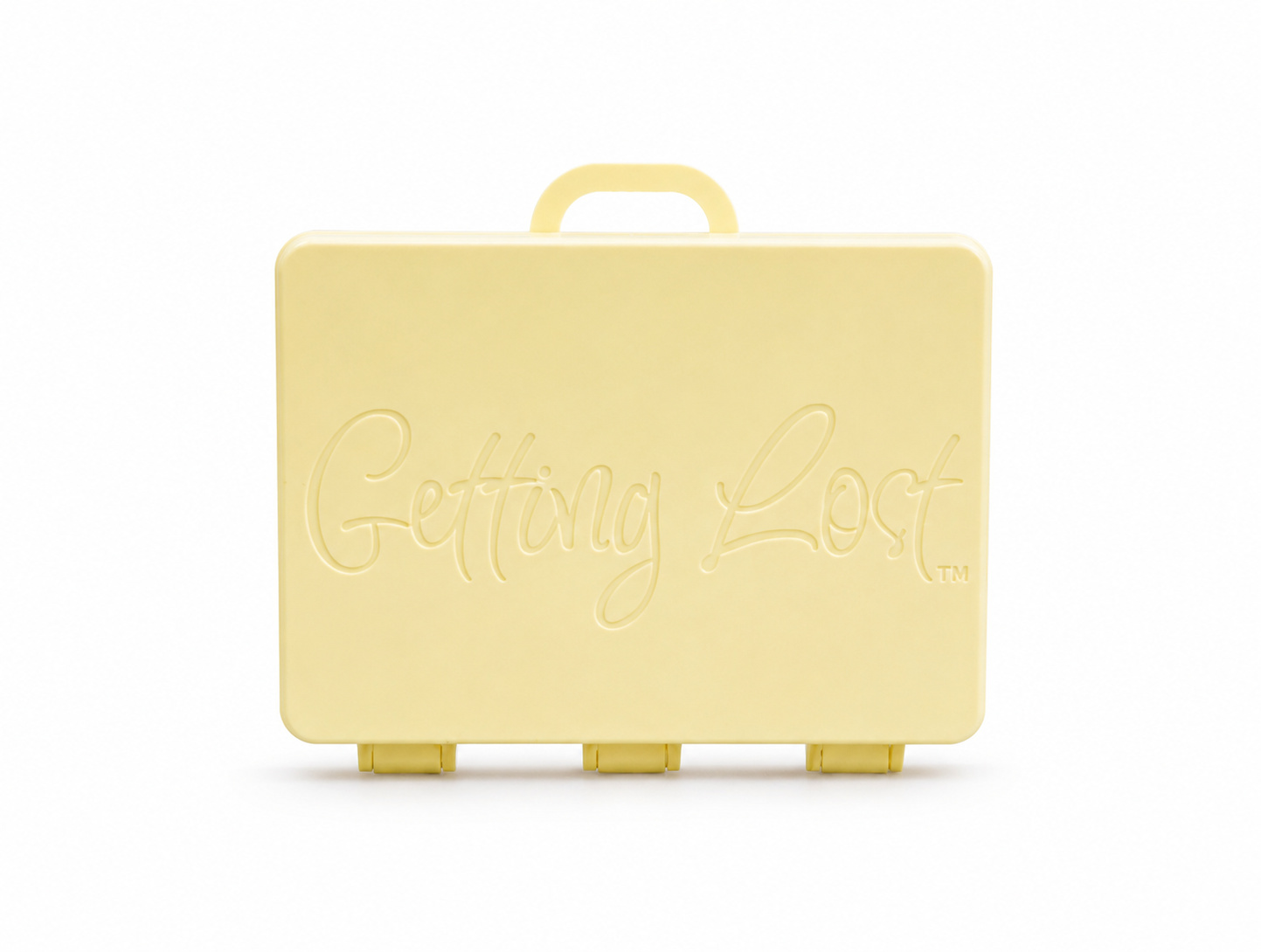 A beach sands rectangular carrying case with a top handle, featuring the words 'Getting Lost' embossed on the front, set against a plain white background. For the Getting lost card game. Purchase from Coffee and Moo