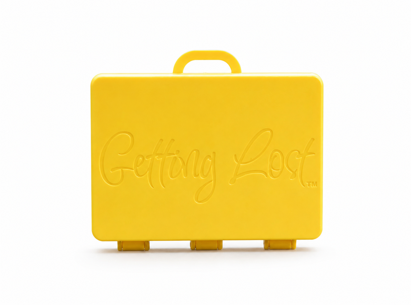 A yellow rectangular carrying case with a top handle, featuring the words 'Getting Lost' embossed on the front, set against a plain white background. For the Getting lost card game. Purchase from Coffee and Moo