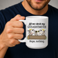 A person holding a white ceramic mug with a humorous graphic that reads 'Let me check my GIVEASHITMETER Nope, nothing.' above three cartoon cows behind a log. Grab your cheeky mug from Coffee and Moo NZ.