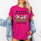 A woman wearing a bright pink graphic t-shirt with a cow design and the text 'Let me check my GIVEASHITMETER Nope, nothing.' She has a light blue denim jacket draped off her shoulders against a plain white background. Grab your from Coffee and Moo NZ.