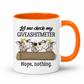 A white ceramic coffee mug with a bright orange handle and interior. The front features a humorous graphic with three cartoon cows wearing yellow crowns and sunglasses behind a log, with the text 'Let me check my GIVEASHITMETER' above and 'Nope, nothing. Grab your cheeky mug from Coffee and Moo NZ.