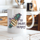 A white ceramic mug with a hand graphic holding a green smudge bundle and the text 'GO SMUDGE YOURSELF' in black, set on a rustic white wooden table with a blurred kitchen background. Purchase from Coffee and Moo NZ.