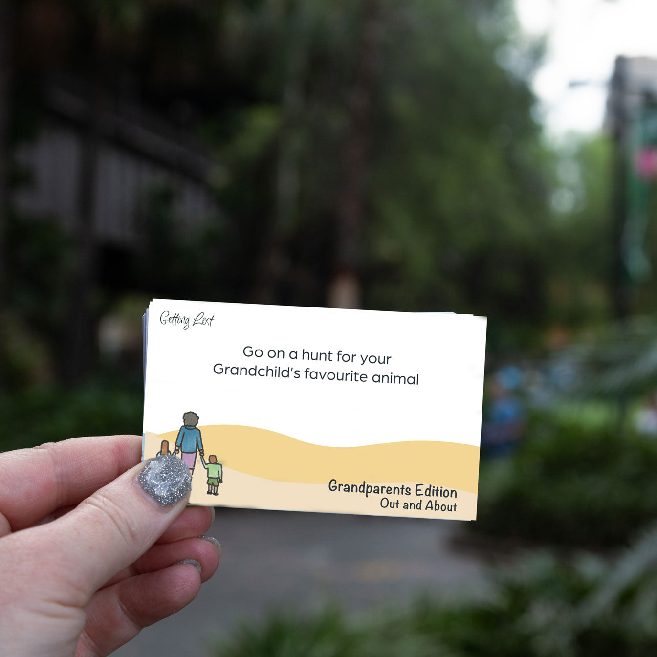 "Getting lost" grandparents edition card game. featuring 30 double sided activity + direction cards. image shows a card from the game with the text " Go on a hunt for your grandchild's favourite animal". Grab yours pack from Coffee and Moo NZ.,