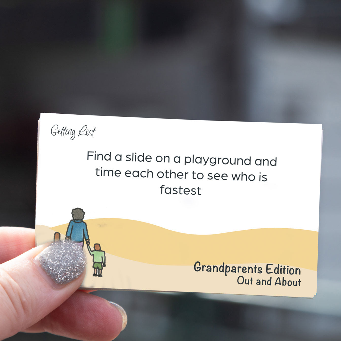 "Getting lost" grandparents edition card game. featuring 30 double sided activity + direction cards. image shows a card from the game with the text " Find a slide on a playground and time each other to see who is fastest. Grab yours pack from Coffee and Moo NZ.,