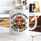 A white ceramic mug with a cartoon Highland cow graphic and the text 'HIGHLAND COWS are my SPIRIT ANIMAL', shown on a white wooden surface with a blurred kitchen background. from Coffee and Moo NZ.
