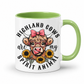 A white ceramic mug with a light green interior and handle, featuring a cartoon illustration of a Highland cow wearing round glasses and a pink bow, surrounded by sunflowers and the text 'HIGHLAND COWS are my SPIRIT ANIMAL'. from Coffee and Moo NZ.