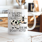 A white ceramic coffee mug with a cartoon cow and the text 'IF SWEARING BURNED CALORIES I'D BE ONE SKINNY HEIFER' placed on a rustic white wooden table with a blurred kitchen background. from Coffee and Moo NZ.