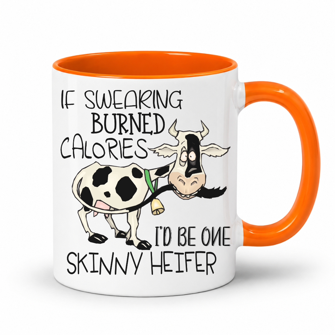 A white ceramic coffee mug with a bright orange handle and interior, featuring a cartoon cow and the humorous text 'IF SWEARING BURNED CALORIES I'D BE ONE SKINNY HEIFER' printed on the front. purchase from Coffee and Moo NZ.