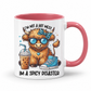A white ceramic mug with a pink interior and handle, featuring a cartoon Highland cow wearing blue sunglasses and a blue bow tie, next to an iced coffee and a blue sneaker. The text reads 'I'M NOT A HOT MESS IM A SPICY DISASTER'. from Coffee and Moo NZ.