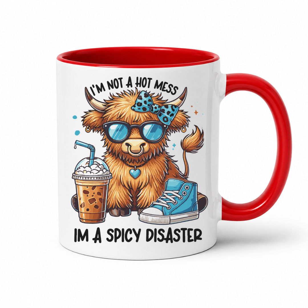 A white ceramic coffee mug with a red interior and red handle, featuring a cartoon highland cow wearing blue sunglasses, a blue patterned headband, and a blue sneaker, with the text 'I'M NOT A HOT MESS' above and 'I'M A SPICY DISASTER' below. from Coffee and Moo NZ.
