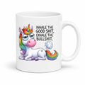 A white ceramic mug featuring a cartoon illustration of a white unicorn with a rainbow mane, horn, and tail, sitting next to the black text 'INHALE THE GOOD SHIT, EXHALE THE BULLSHIT.' on a white background. Purchase from Coffee and Moo NZ.
