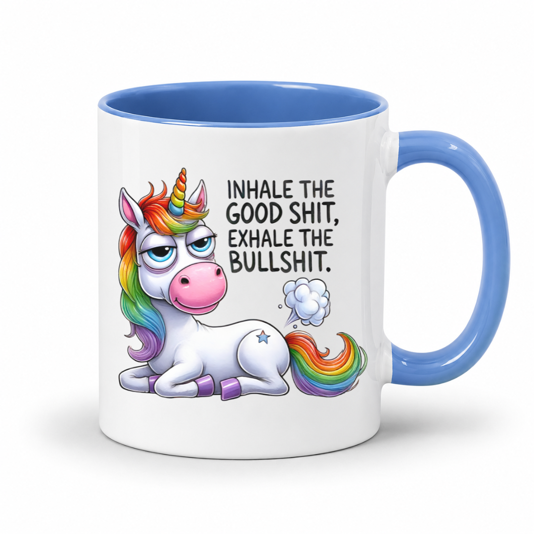A white ceramic mug with a blue interior and handle, featuring a cartoon rainbow unicorn and the text 'INHALE THE GOOD SHIT, EXHALE THE BULLSHIT.' on a clean white background. Purchase from Coffee and Moo NZ.