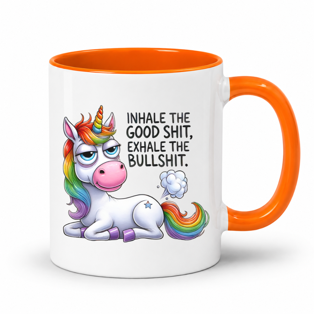A white ceramic coffee mug with a bright orange handle and interior, featuring a cartoon illustration of a white unicorn with a rainbow mane and tail, and the text 'INHALE THE GOOD SHIT, EXHALE THE BULLSHIT.' on the front. Purchase from Coffee and Moo NZ.