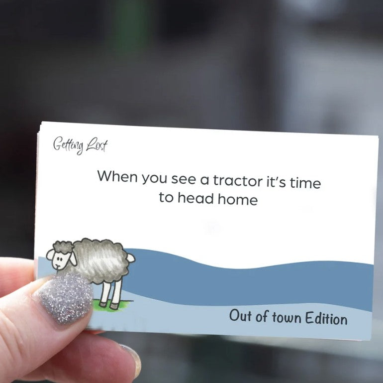 Discover rural NZ with the Getting Lost Kiwi Out of Town card game. Image shows text "when you see a tractor it's time to head home". there is 15 direction + activity cards. grab yours from coffee and moo NZ.