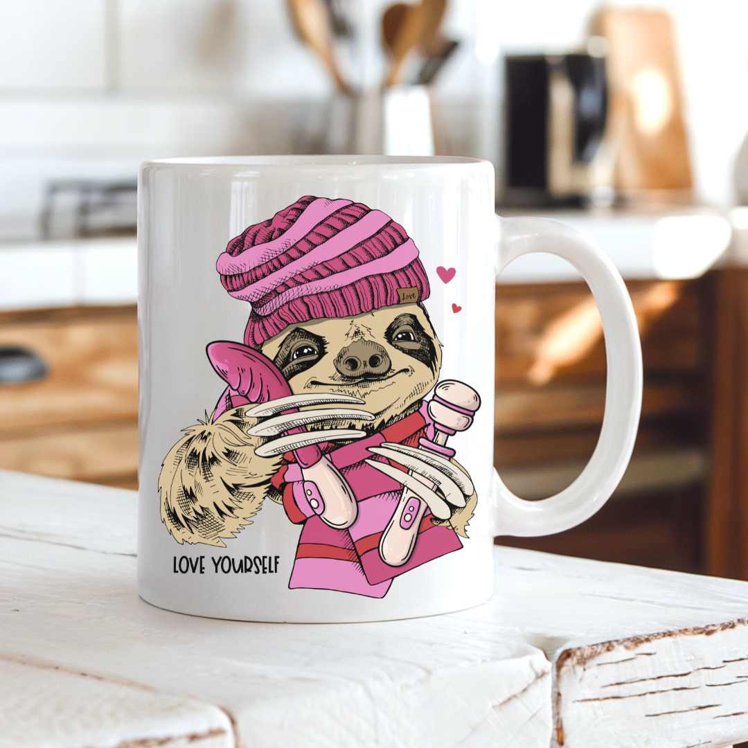 Love Yourself Naughty Sloth funny coffee mug on a country kitchen bench, featuring a pink-clad sloth holding adult toys and Love Yourself lettering, by Coffee and Moo.