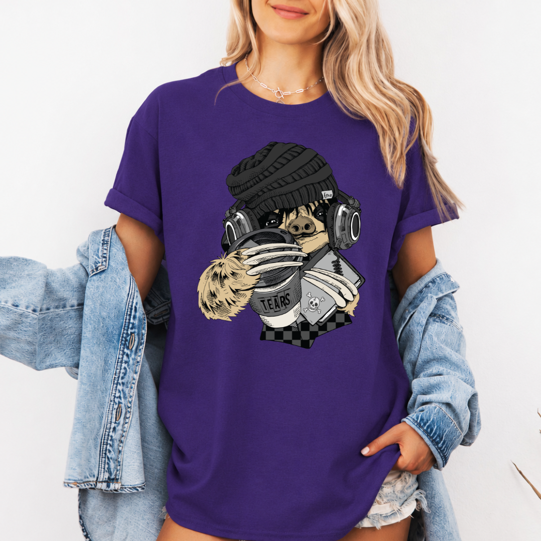 A woman wearing a purple short-sleeve graphic t-shirt with a stylized Emo sloth wearing a beanie, headphones, and holding a coffee cup with the word "TEARS" on it. Grab your tee from Coffee and Moo NZ.