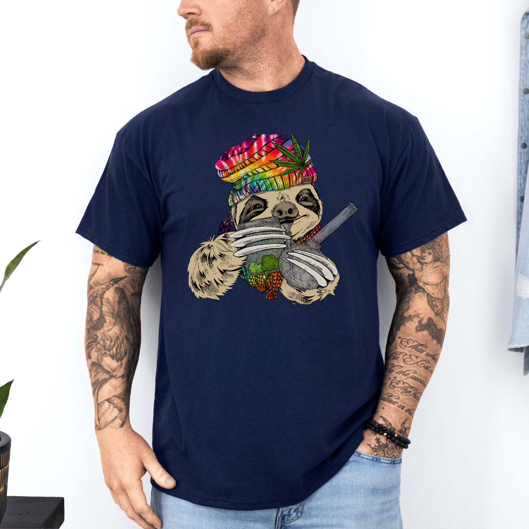 A man wearing a navy unhinged adult graphic tee features our resident zen master—a delightfully baked sloth rocking a vibrant, colourful tie-dye beanie topped with a cannabis leaf, proudly clutching a bong and a jar of premium green buds. Grab your sloth stoner tee from Coffee and Moo NZ.