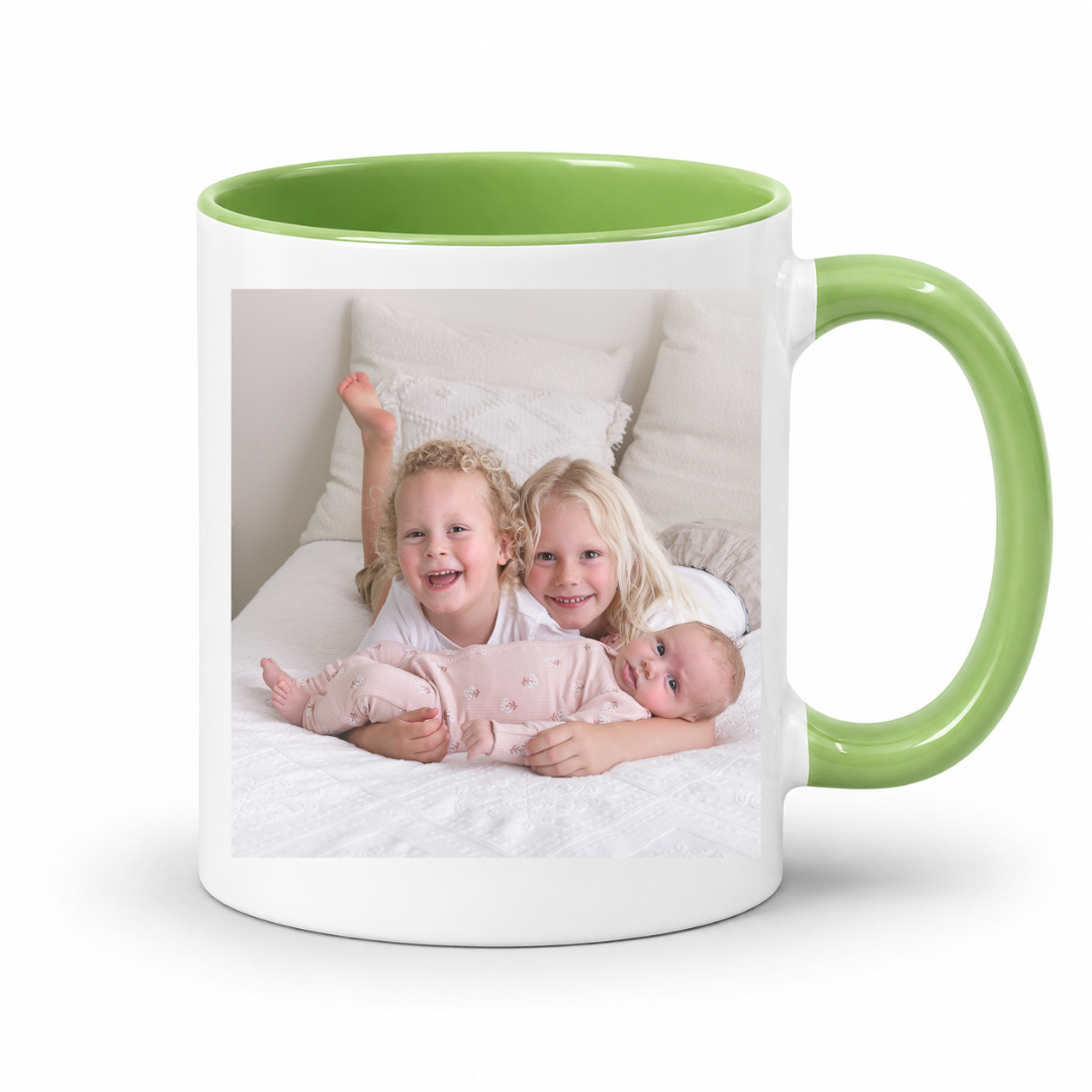 A white ceramic mug with a bright green interior and handle, featuring a printed custom photo of three children on the front, set against a plain white background. Grab your custom photo mug from Coffee and Moo NZ.
