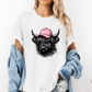 A woman wearing a white graphic t-shirt with a black highland cow illustration wearing a pink 'BOSSY' cap. She has a light blue denim jacket draped off her shoulders and is posing against a clean white background.  Grab your tee from Coffee and Moo NZ.