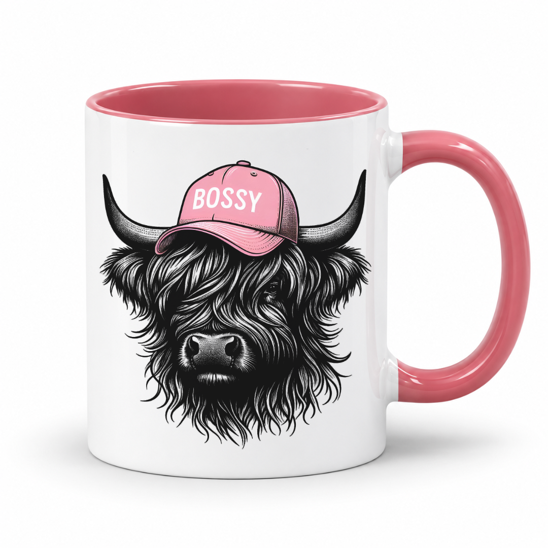 pink handle and inner mug with an image of a black Bossy Highland Cow wearing a Pink Cap. Mug is set on a white background .grab your bossy  mug from Coffee and Moo NZ.