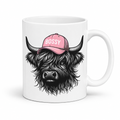 white mug with an image of a black Bossy Highland Cow wearing a Pink Cap. Mug is set on a white background .grab your bossy  mug from Coffee and Moo NZ.