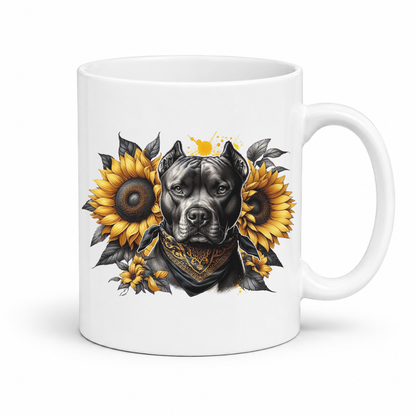 A white ceramic coffee mug featuring a graphic print of a black pitbull dog wearing a black & gold bandana, framed by two large yellow sunflowers with dark leaves. Grab your mug from Coffee and Moo NZ.