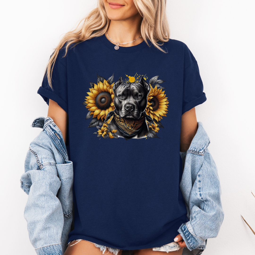 A woman wearing a navy graphic t-shirt with a printed design of a dark coloured pitbull dog wearing a black and gold bandana, surrounded by yellow sunflowers. Grab your tee from Coffee and Moo NZ.