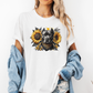 A woman wearing a white graphic t-shirt with a printed design of a dark coloured pitbull dog wearing a black and gold bandana, surrounded by yellow sunflowers. Grab your tee from Coffee and Moo NZ.