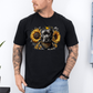 A man wearing a black short-sleeve graphic t-shirt featuring a detailed print of a pitbull dog wearing a bandana and surrounded by yellow sunflowers. The man has tattoos on both arms and is wearing light blue jeans, standing against a white wall. Grab your tee from coffee and moo NZ.