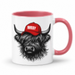A white ceramic mug with a pink interior and handle, featuring a graphic of a shaggy Highland cow wearing a red cap with the word 'BOSSY' in white text. Grab your Bossy highland coo mug from Coffee and Moo NZ.
