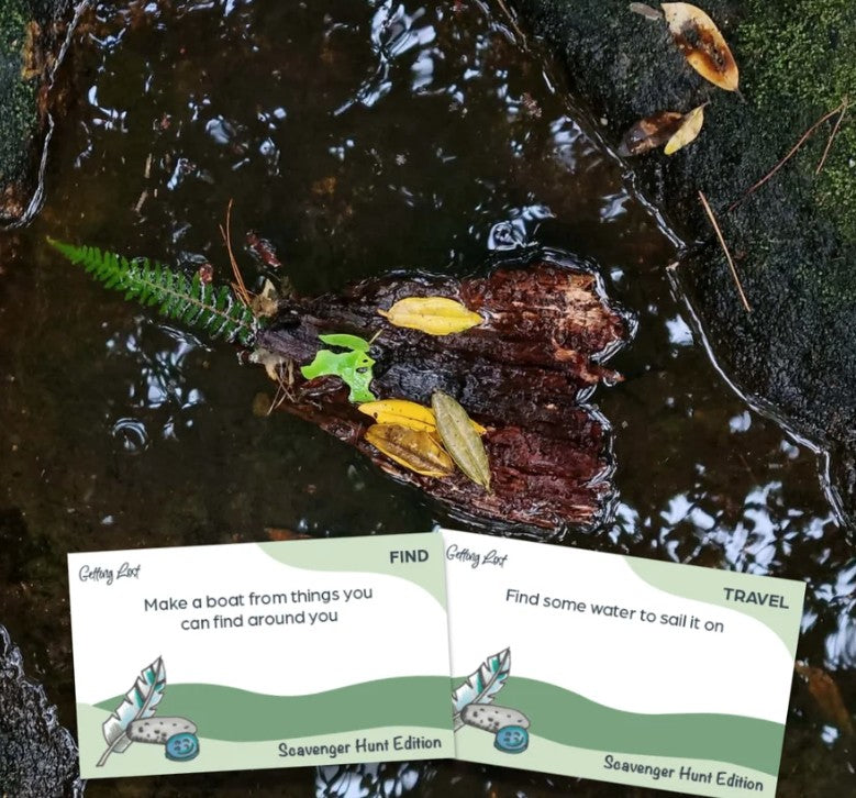 The Getting Lost Scavenger Hunt Edition. image shows 2 cards from the game. The cards show prompts like 'Make a boat from things you can find around you' and 'Find some water to sail it on. Grab your game now from Coffee and Moo NZ.