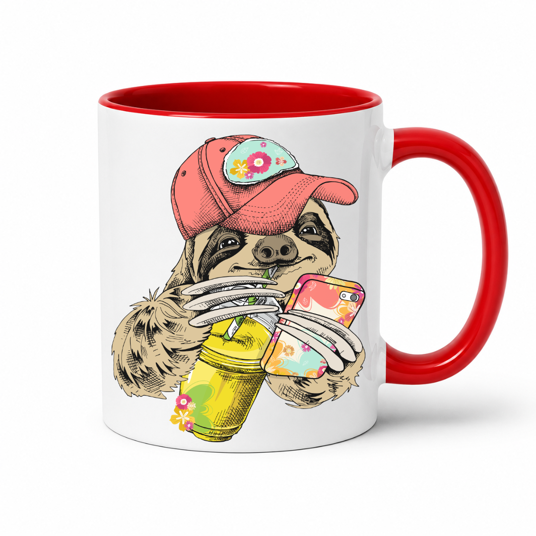 A white ceramic mug with a red interior and red handle, with a colorful illustration of a sloth wearing a coral coloured cap and holding a loaded-tea drink and a phone, set on a  white  background. Grab yours from Coffee and Moo NZ.