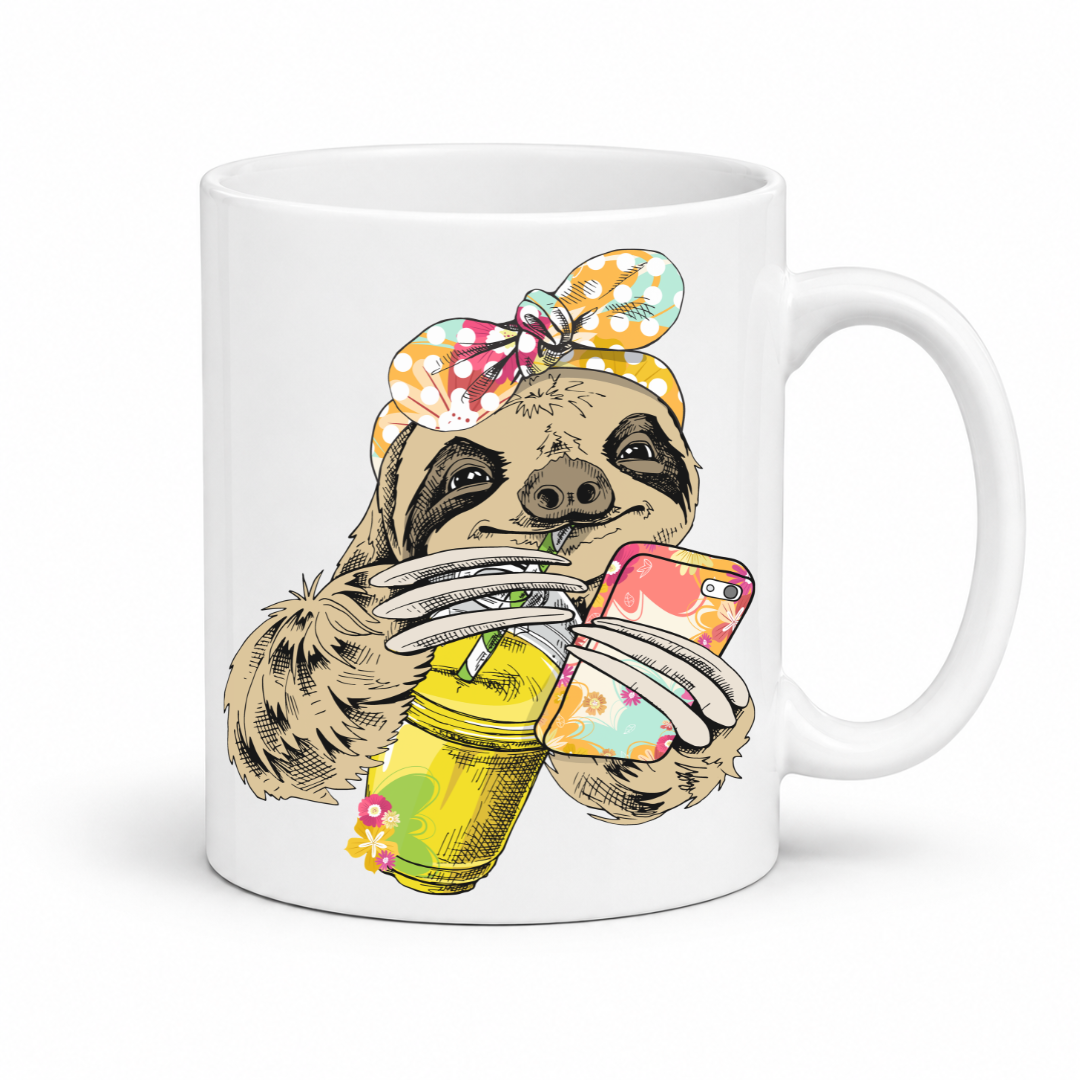 A white ceramic mug with a colorful illustration of a sloth wearing a polka dot bandana and holding a loaded-tea drink and a phone, set on a  white  background. Grab yours from Coffee and Moo NZ.