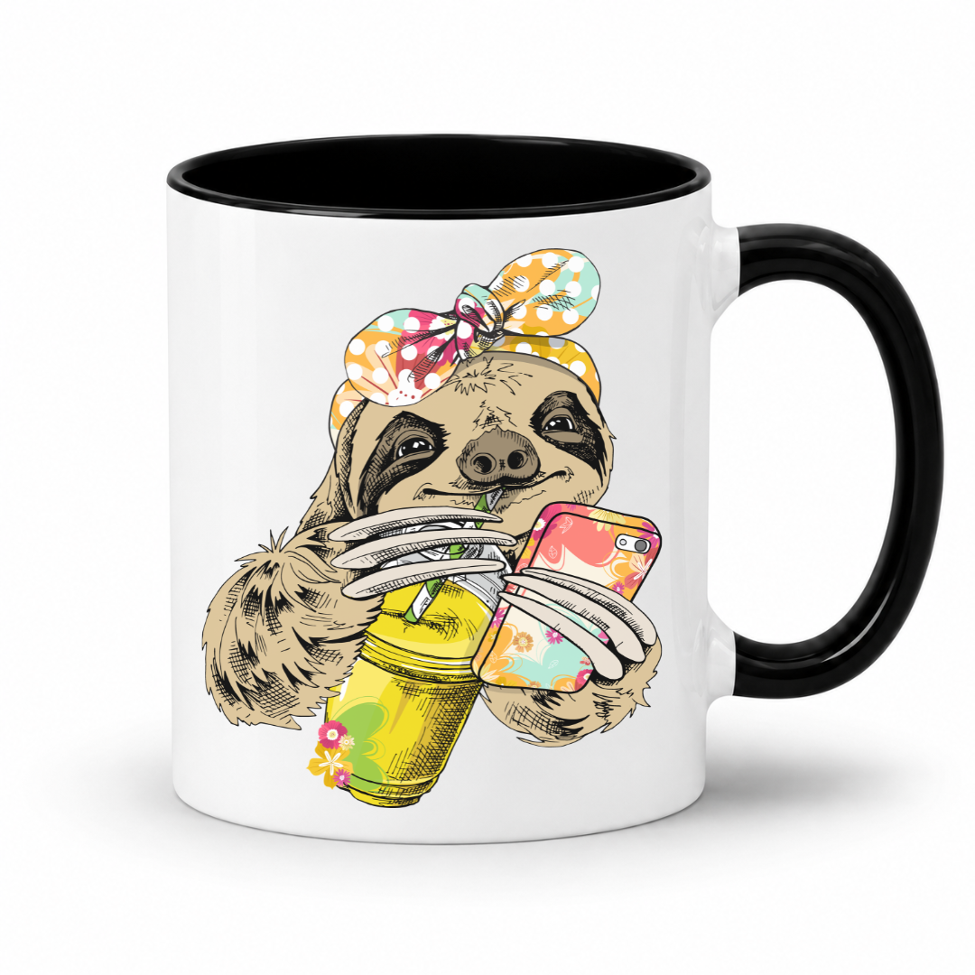 A white ceramic mug with a black interior and black handle, with a colorful illustration of a sloth wearing a polka dot bandana  and holding a loaded-tea drink and a phone, set on a  white  background. Grab yours from Coffee and Moo NZ.