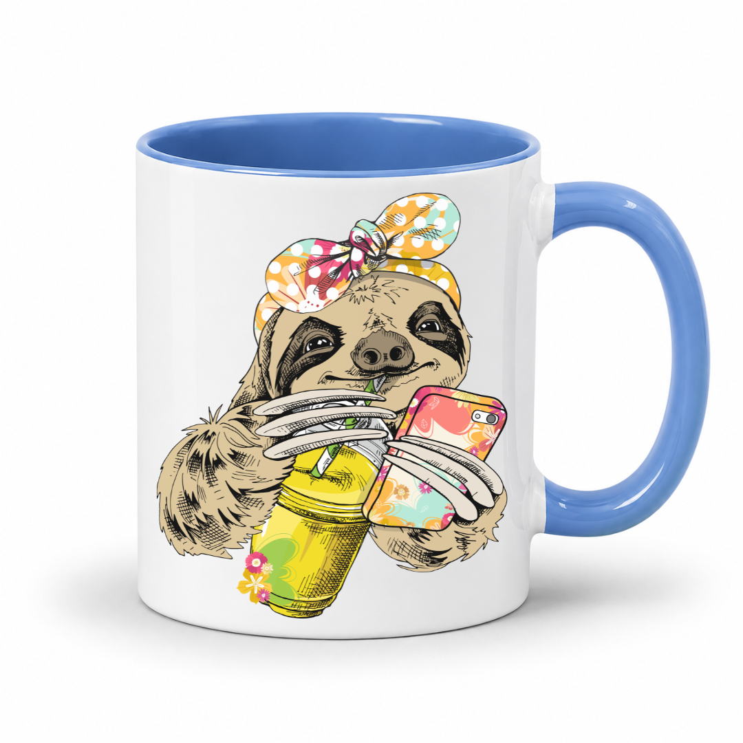 A white ceramic mug with a blue interior and blue handle, with a colorful illustration of a sloth wearing a polka dot bandana  and holding a loaded-tea drink and a phone, set on a  white  background. Grab yours from Coffee and Moo NZ.