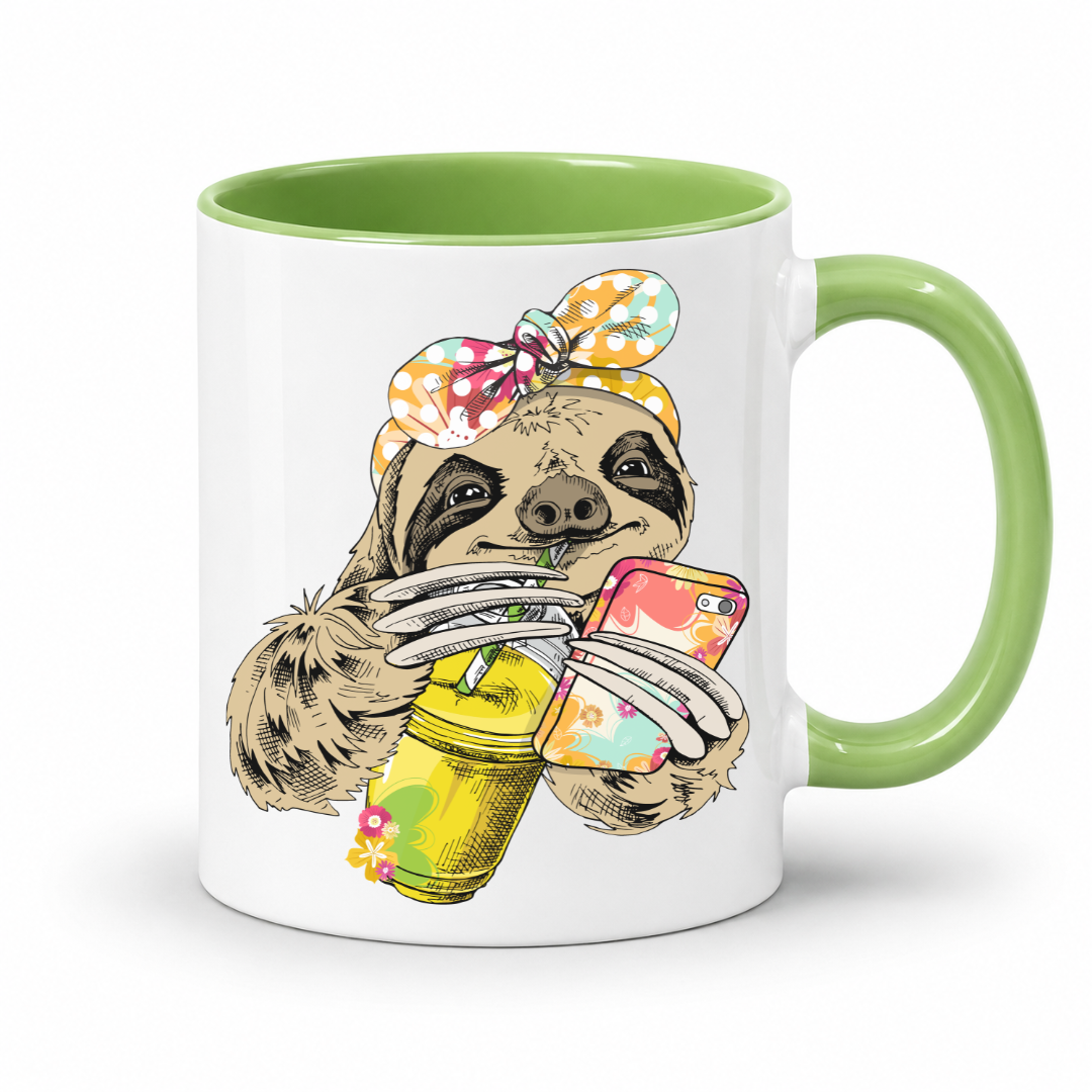 A white ceramic mug with a green interior and green handle, with a colorful illustration of a sloth wearing a polka dot bandana  and holding a loaded-tea drink and a phone, set on a  white  background. Grab yours from Coffee and Moo NZ.