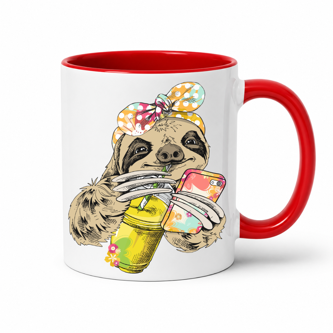 A white ceramic mug with a red interior and red handle, with a colorful illustration of a sloth wearing a polka dot bandana and holding a loaded-tea drink and a phone, set on a  white  background. Grab yours from Coffee and Moo NZ.