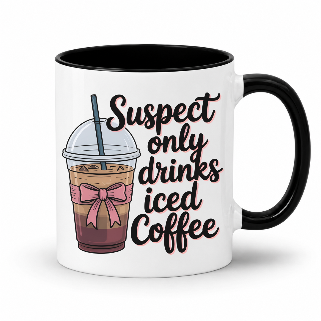 A white ceramic coffee mug with a black handle and black interior, featuring a graphic of an iced coffee cup with a pink bow and the text 'Suspect only drinks iced Coffee' in black script with a pink outline. From Coffee and Moo NZ.