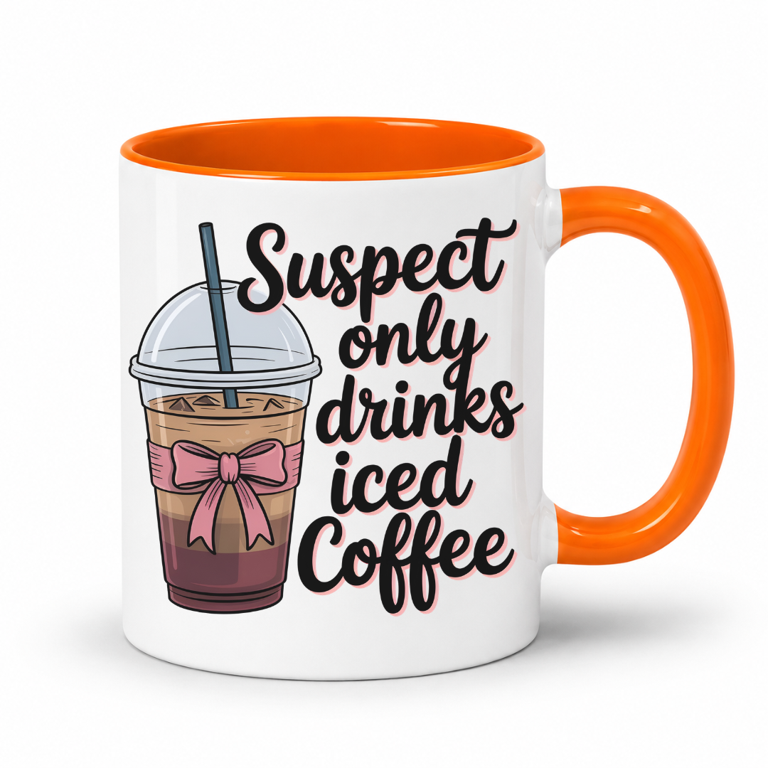 A white ceramic coffee mug with a bright orange handle and interior. The mug features a cartoon illustration of an iced coffee drink with a pink bow and the text 'Suspect only drinks iced Coffee' in black script. From Coffee and Moo NZ.