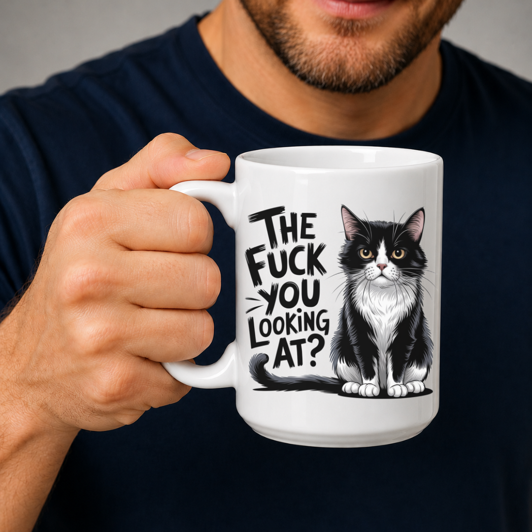 Male holding The Fuck You Looking At? Funny Black & White Cat Mug humorous coffee mug, showcasing the design and comfortable grip, by Coffee and Moo.