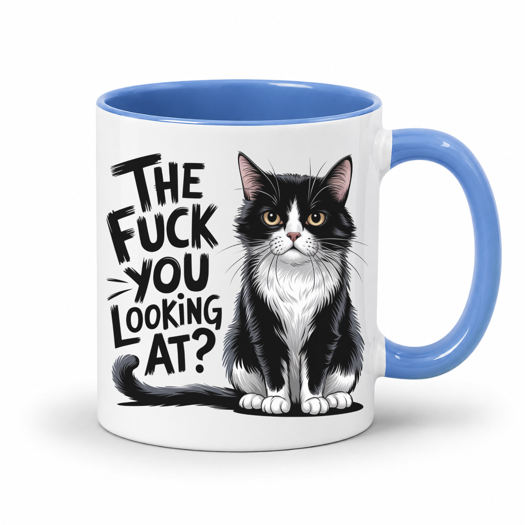 A white ceramic coffee mug with a blue interior and handle, featuring a black and white cat illustration and the text 'THE FUCK YOU LOOKING AT?' printed on the side.